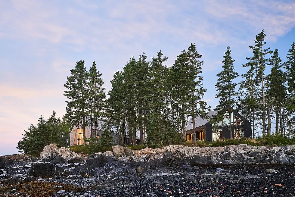 The Sheds of Charlotte County, viewed from below on the beach with a low tide, showing 2 of 3 shingle clad buildings with large windows