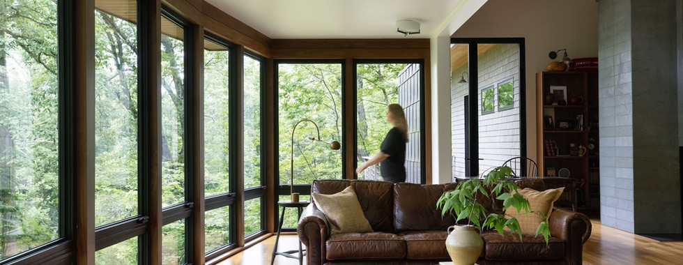 Huge full length picture windows cover this living room's wall, with operable awning window for airflow