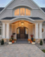 Front entry view of custom home with Marvin round top windows and staind mahogany entry door.