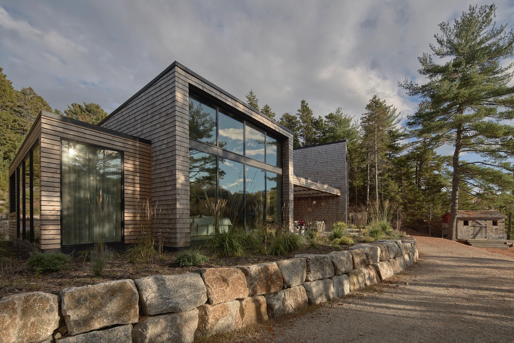 Sunnybrook sanctuary custom home exterior view frmo below rock retaining wall