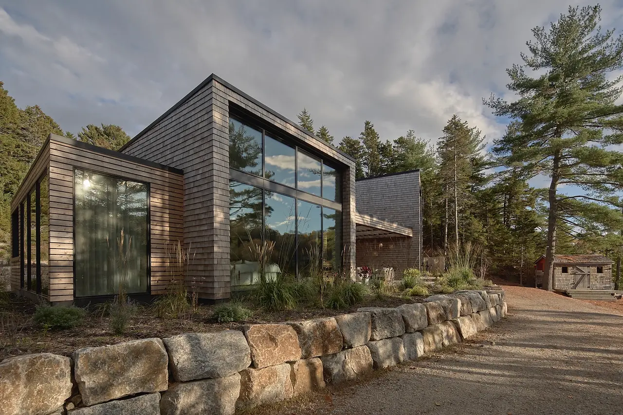 Sunnybrook sanctuary custom home exterior view frmo below rock retaining wall
