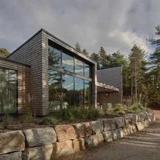 Sunnybrook sanctuary custom home exterior view frmo below rock retaining wall