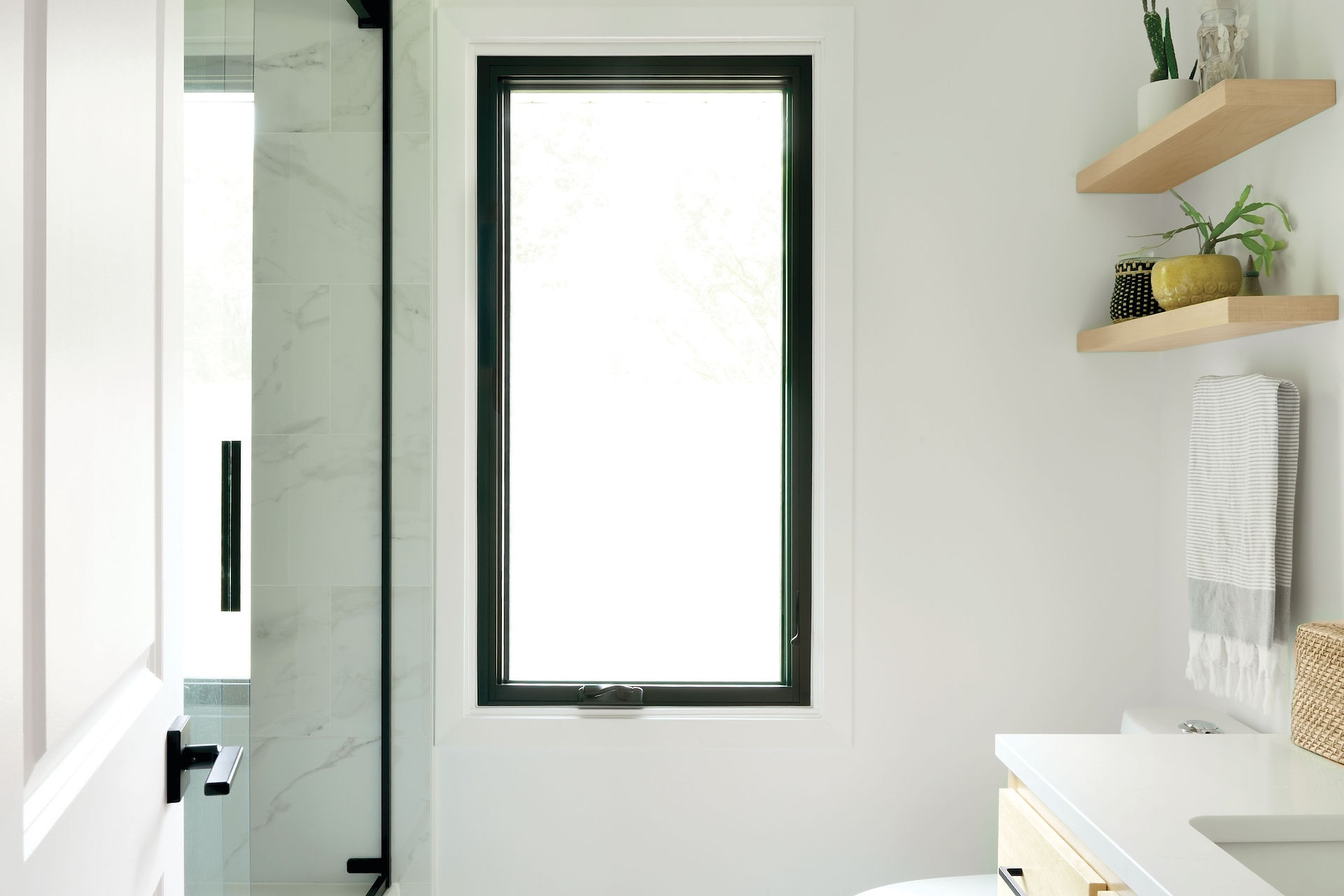 La fenêtre à battants de la salle de bain apporte beaucoup de lumière naturelle diffuse à cette salle de bain tout en préservant l'intimité.