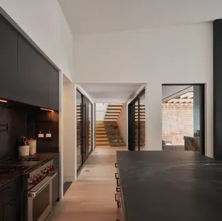 Sunnybrook sanctuary custom home interior view through the kitchen towards the entry door and staircase to bedrooms