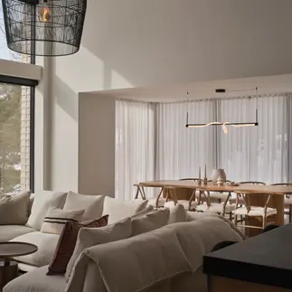 Sunnybrook sanctuary custom home interior living and dining room with bright sunlight filtering in through the window wall