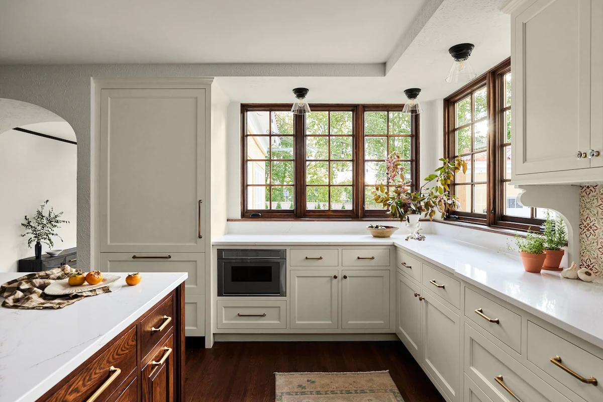 Wooden fixed & casement windows line the wall behind kitchen counters in traditional home