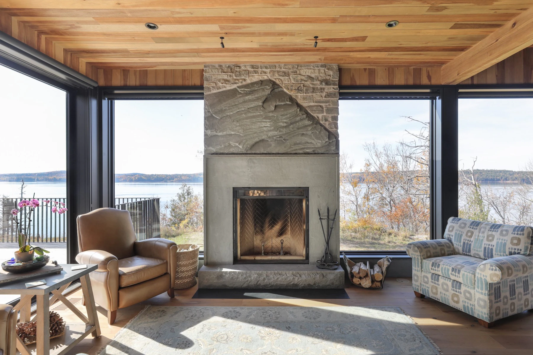 Main fireplace in living room with flagstone mantle, surrounded by large Marvin picture windows