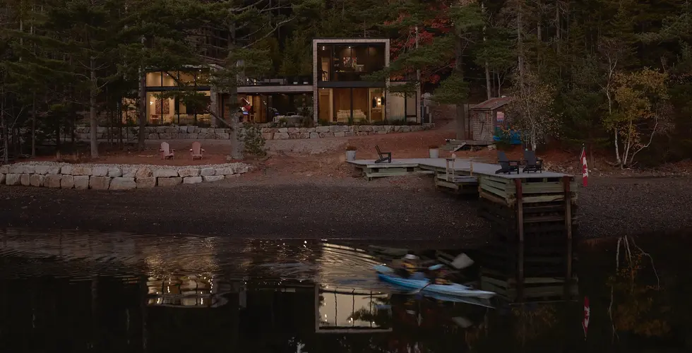 Sunnybrook sanctuary custom home exterior view at dusk, loooking across the water