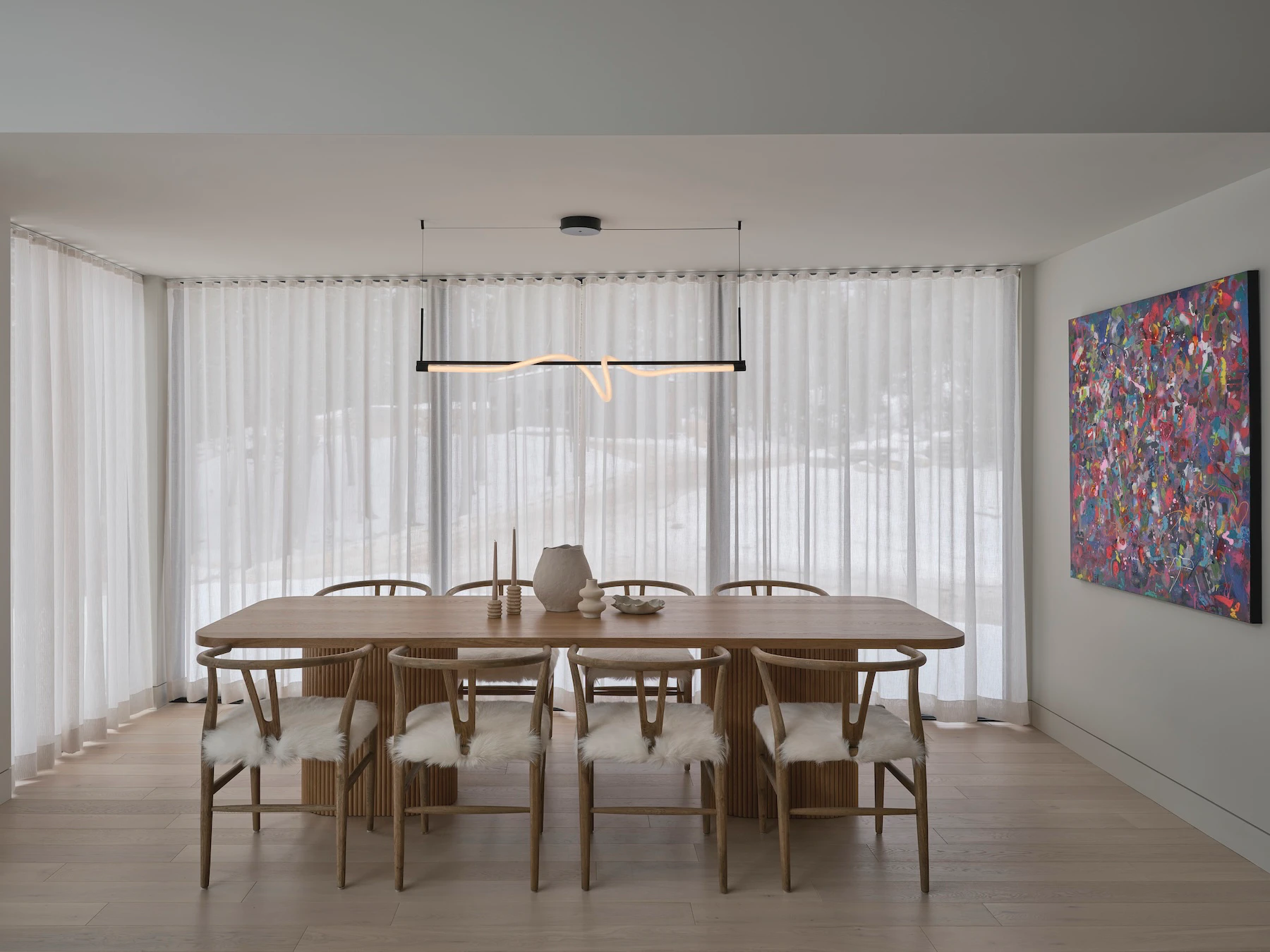 Sunnybrook sanctuary custom home interior dining room with moden rope style light fixture and large windows covered by semi transparent curtains