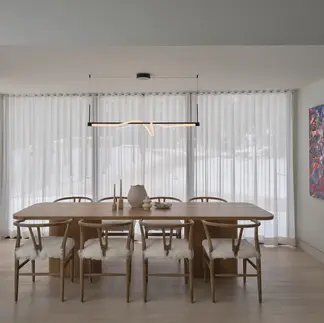 Sunnybrook sanctuary custom home interior dining room with moden rope style light fixture and large windows covered by semi transparent curtains