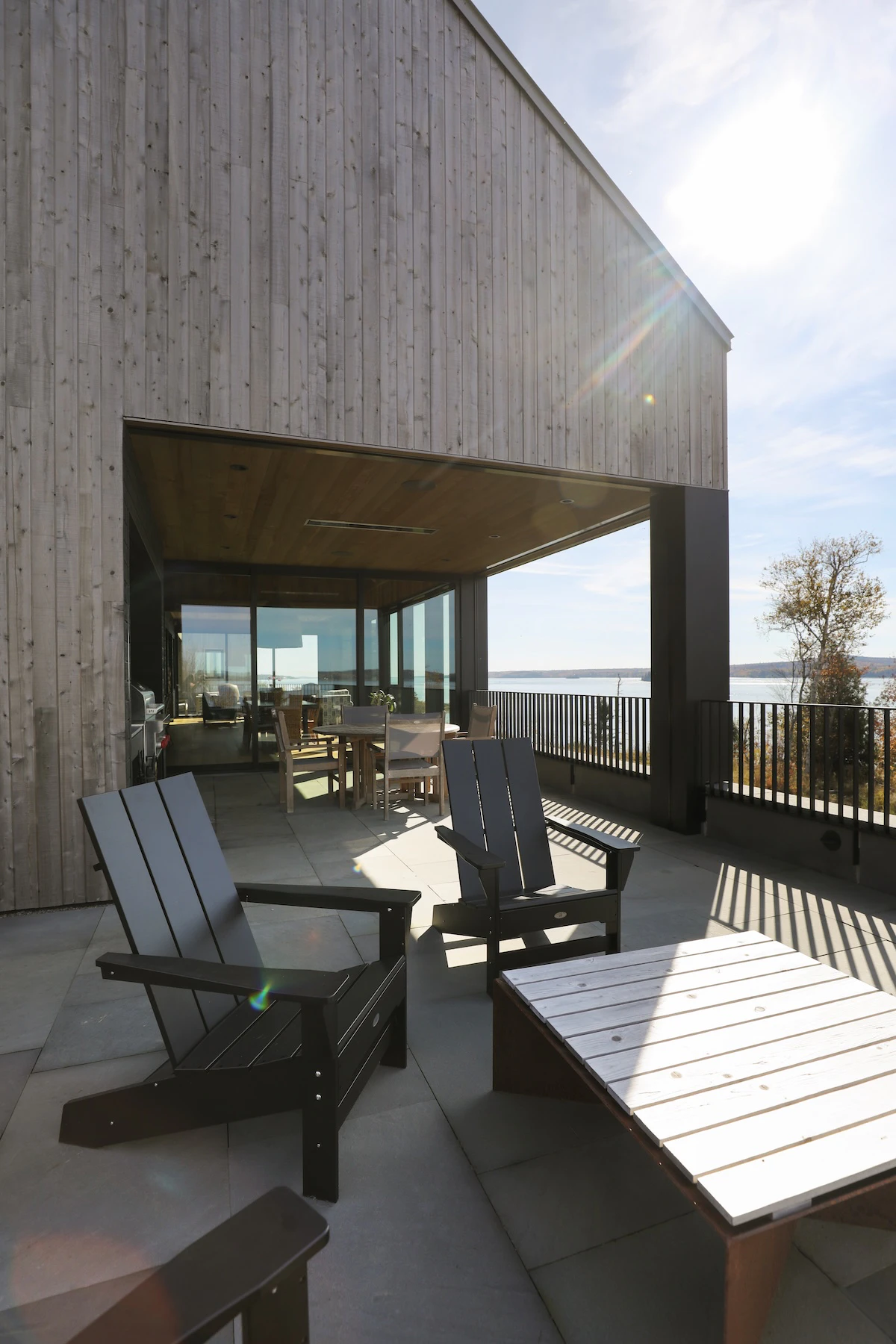 Adirondack chairs surround fireplace on the patio of St. Croix Homestead in New Brunswick