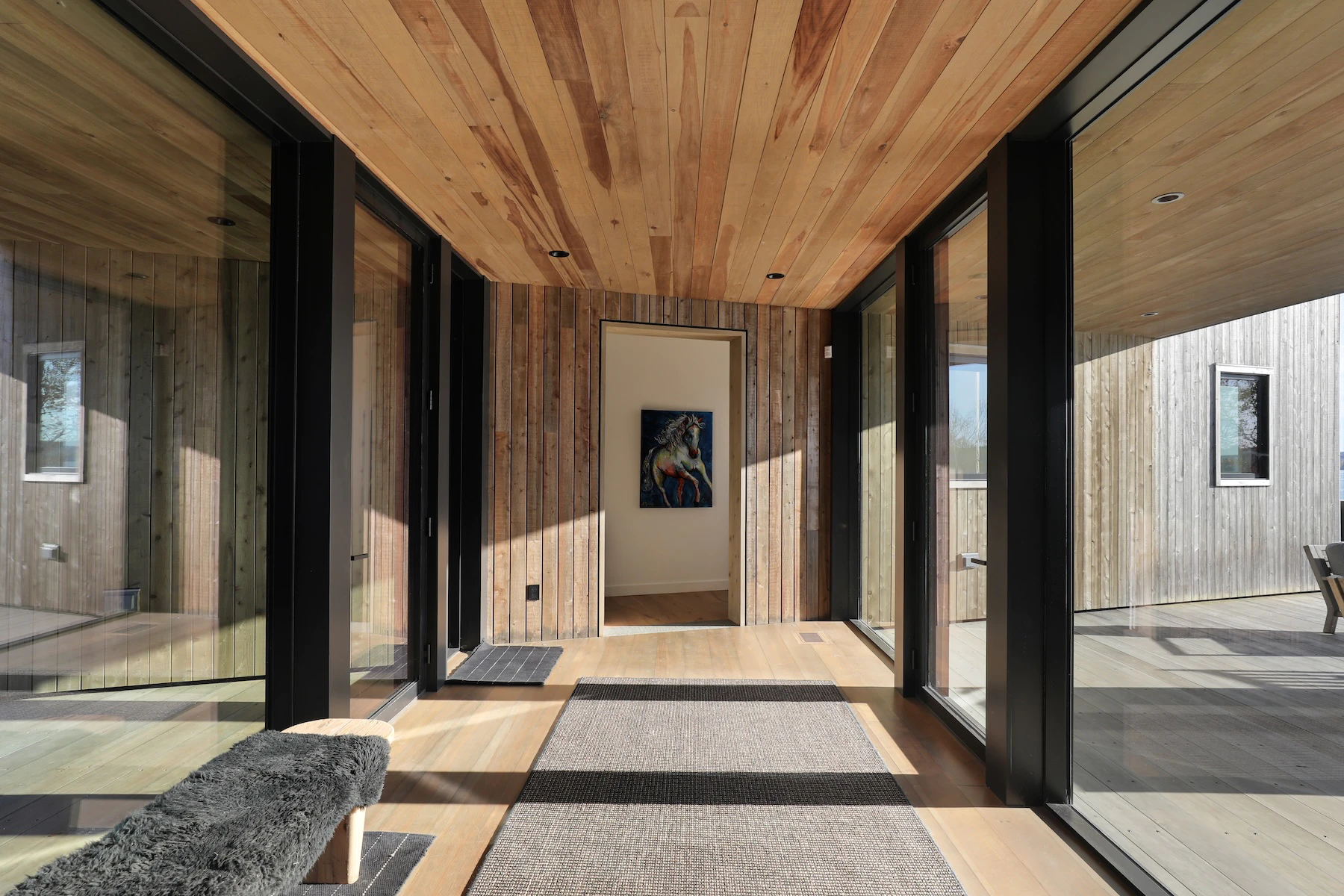 Interior of main entryway featuring glass on both sides, revealing the stunning water view upon entrance.