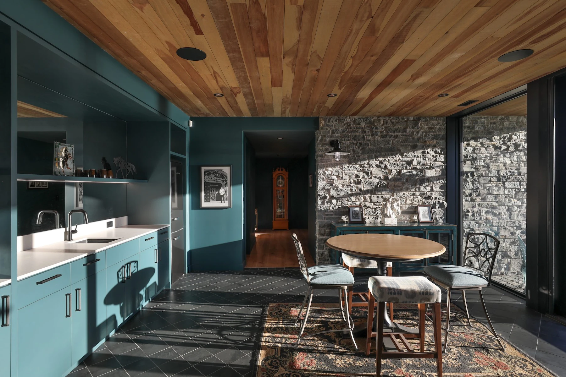 Light floods a turqoise kitchen through large Marvin picture windows