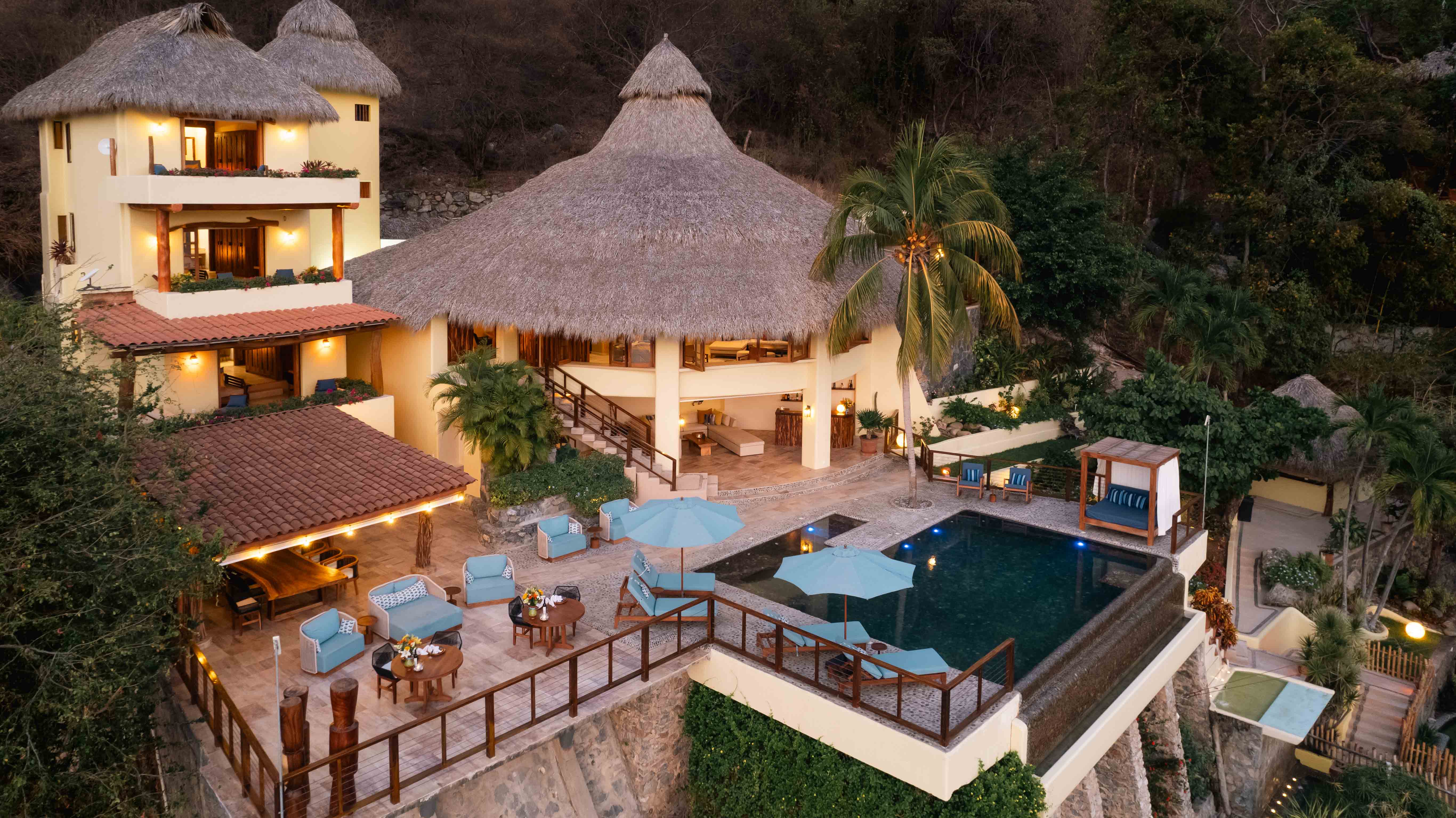 Villa Escala luxury cliffside property with illuminated pool and mountain backdrop at twilight