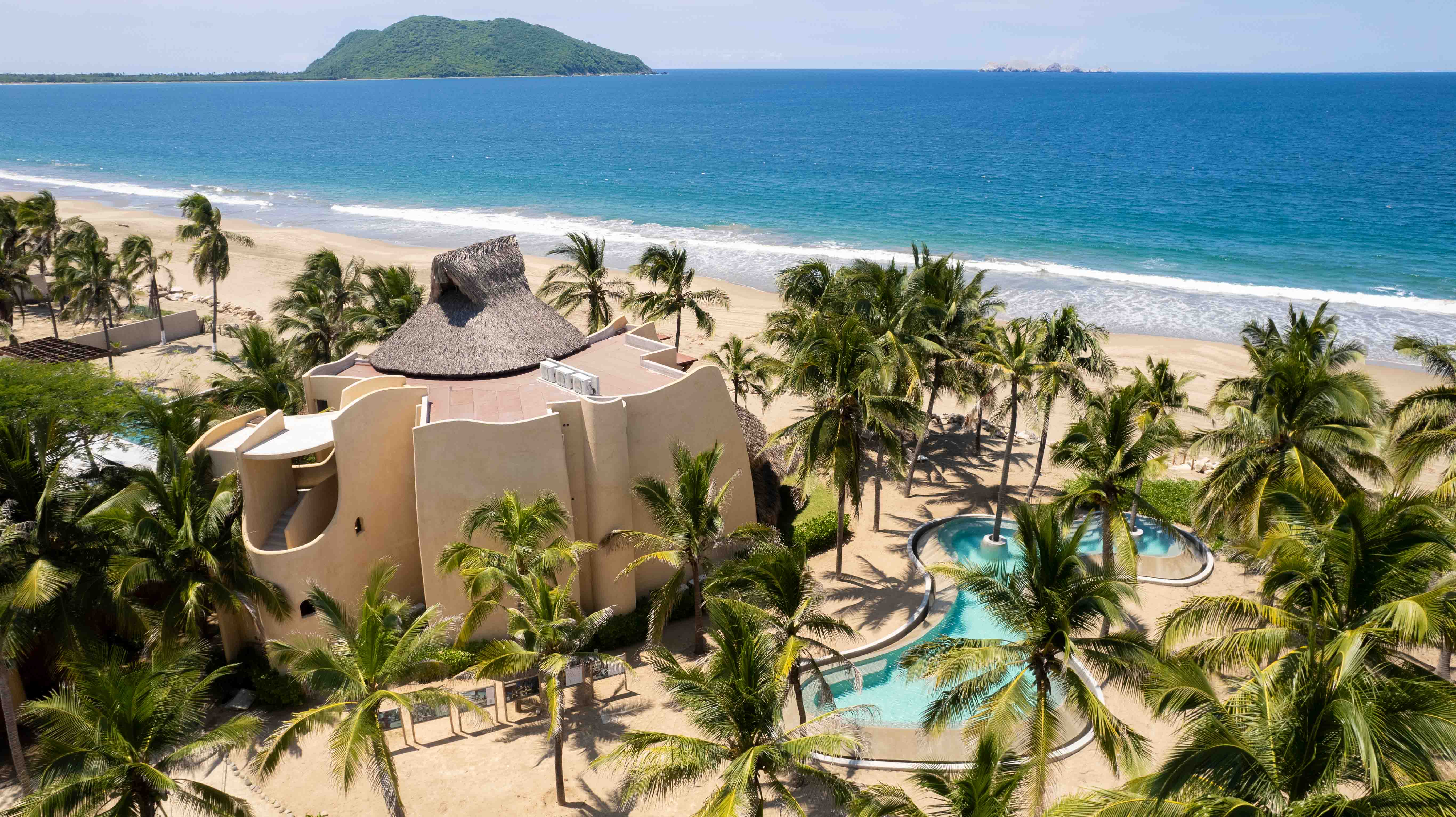 Mar de Coco architecture with pool, palm trees and Pacific Ocean in a tropical setting in Mexico