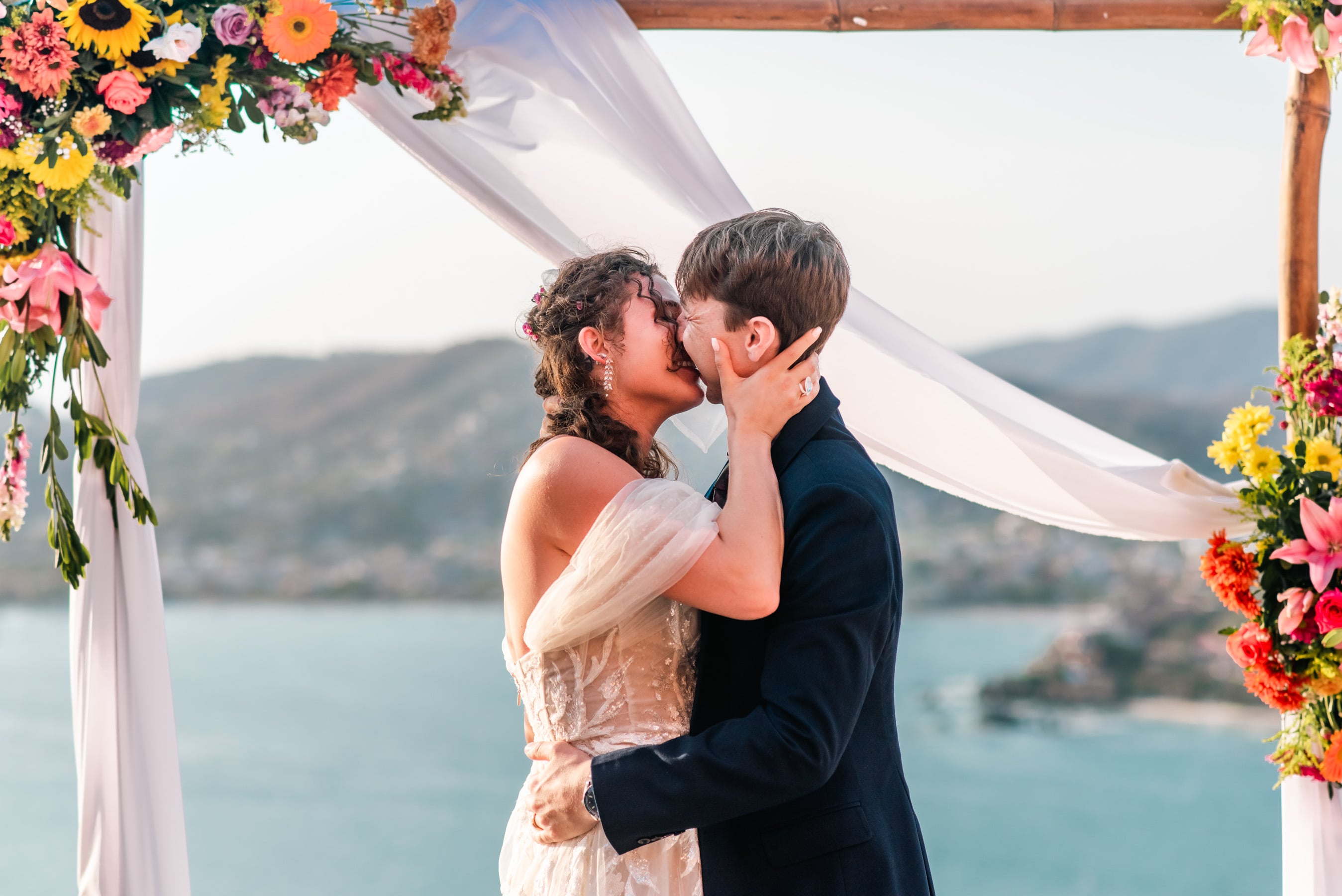 Bride and groom exchange rings against the backdrop of a vibrant tropical garden, framed by lush foliage