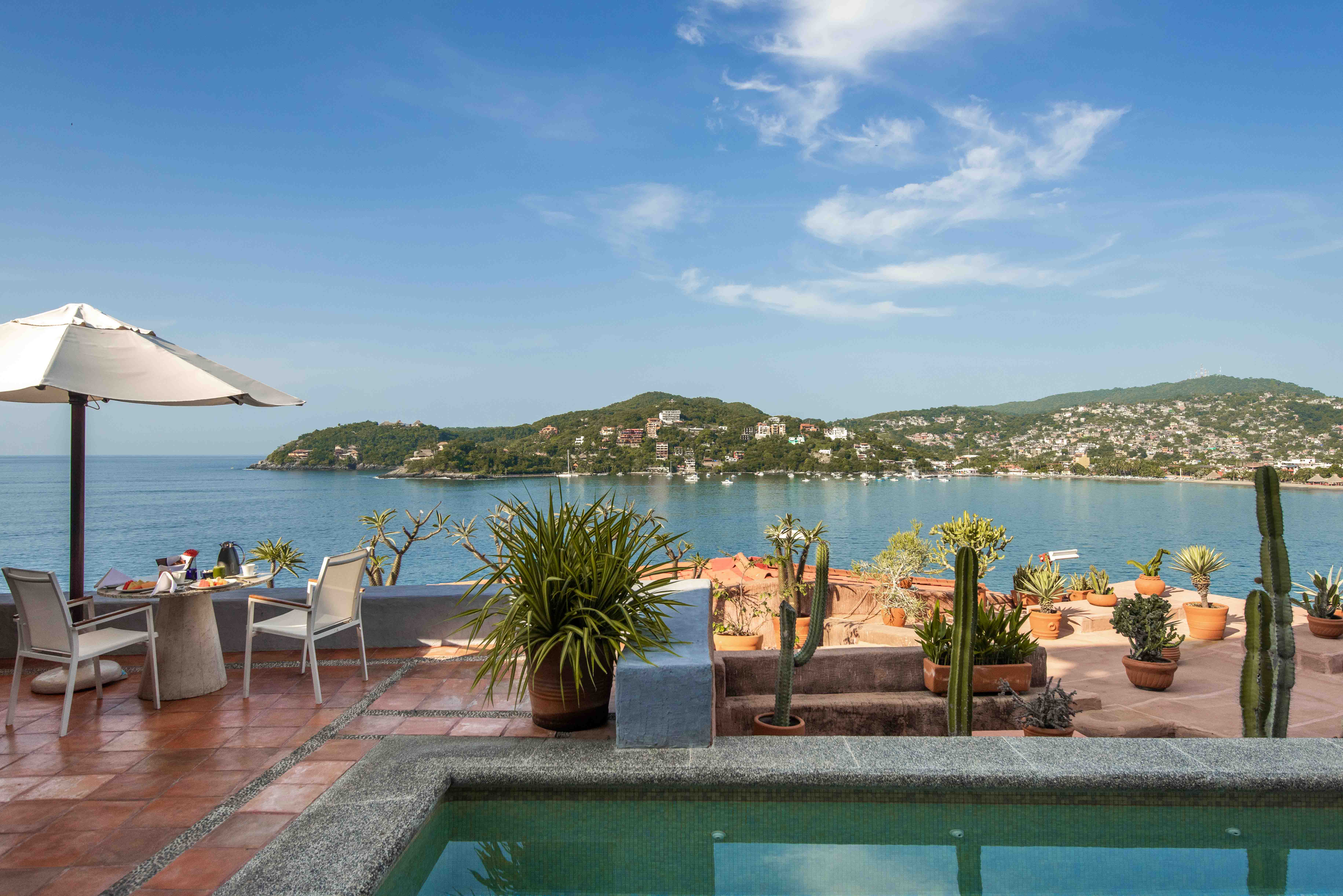 Villa exterior with pool, breakfast terrace and Pacific Ocean views at La Casa Que Canta in Zihuatanejo