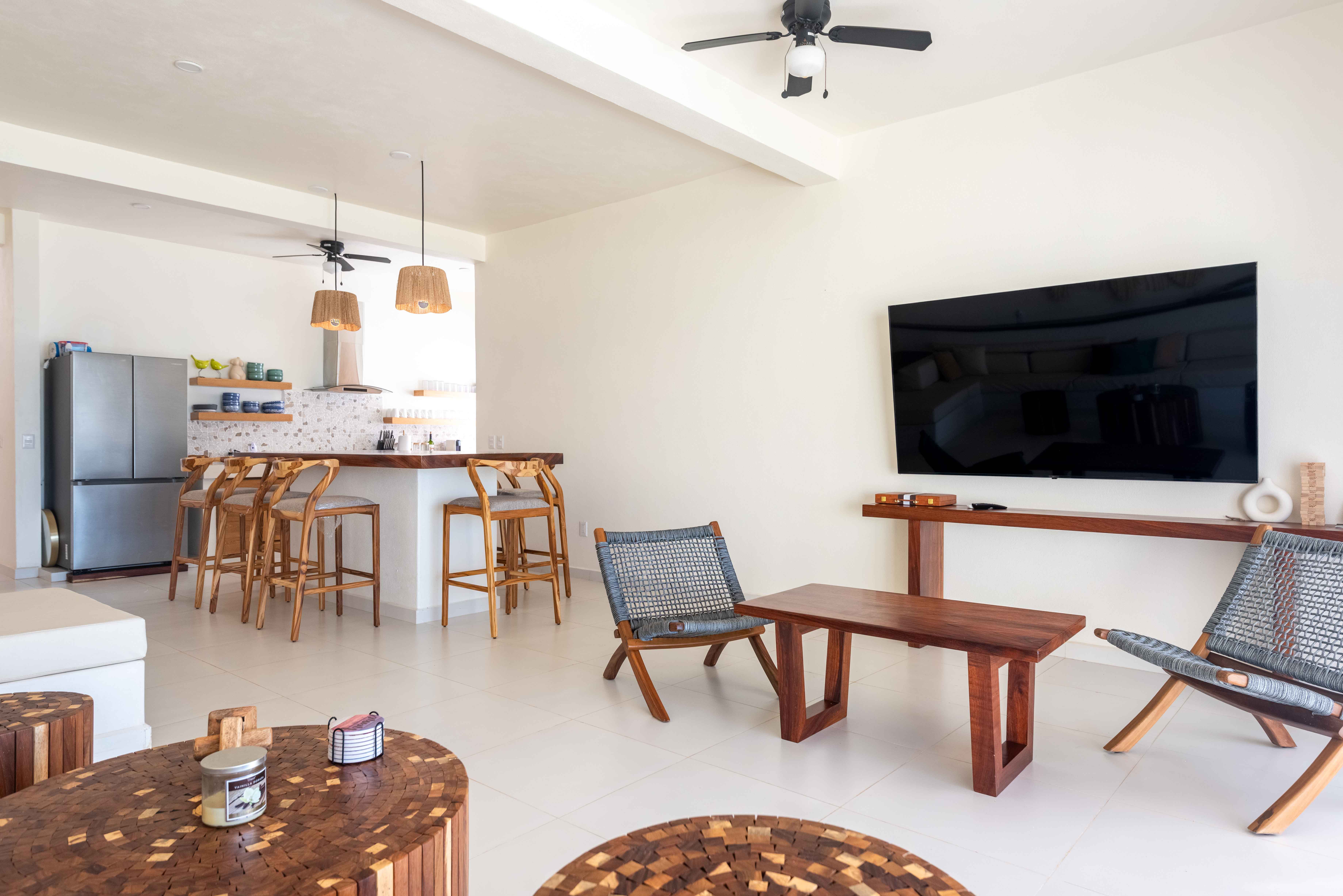 Modern living room and kitchen with wood furniture and white sofas in Mexico