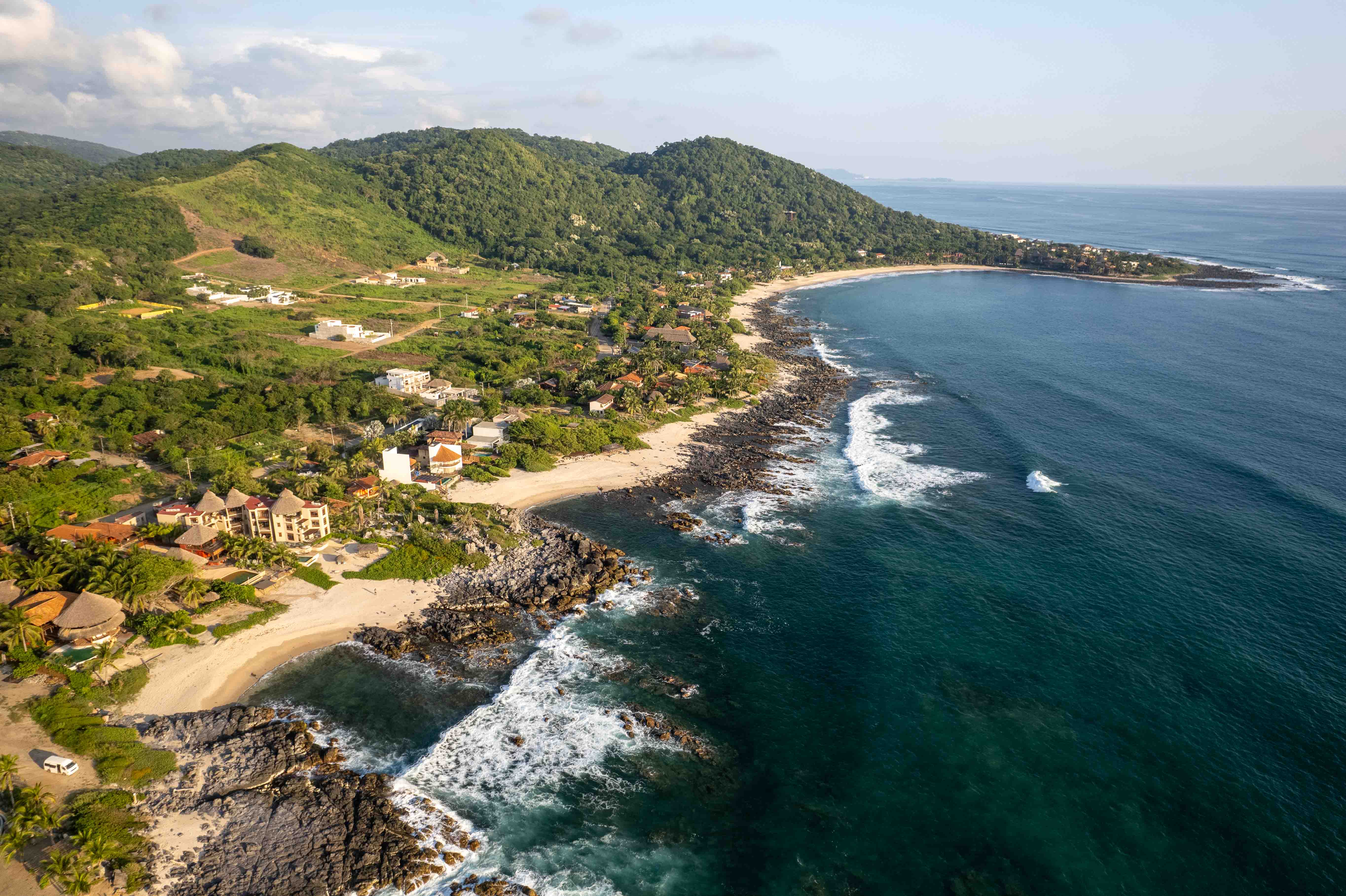 Drone view of Nerea beachfront property surrounded by beach and tropical landscape in Troncones