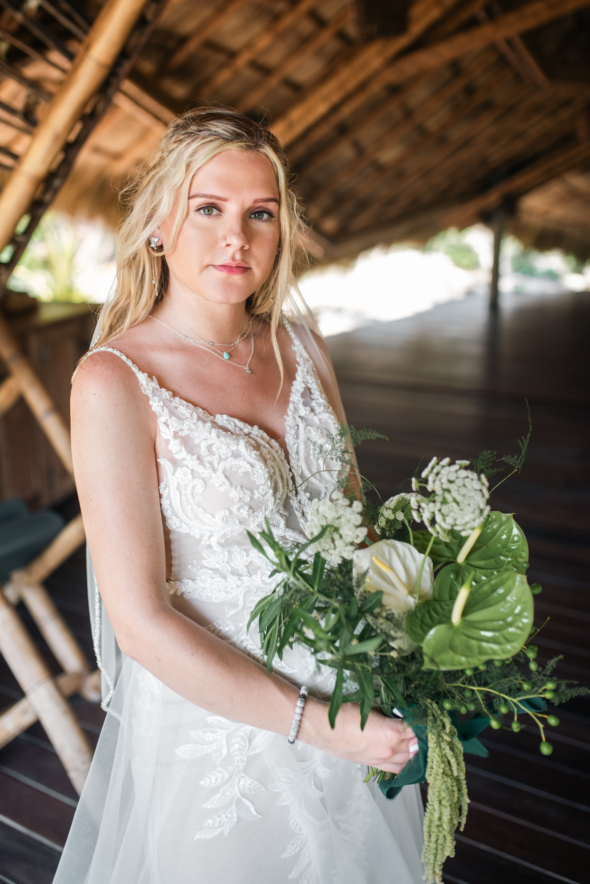Boho-style bridal portrait with palm trees and eco-luxury backdrop at Playa Viva