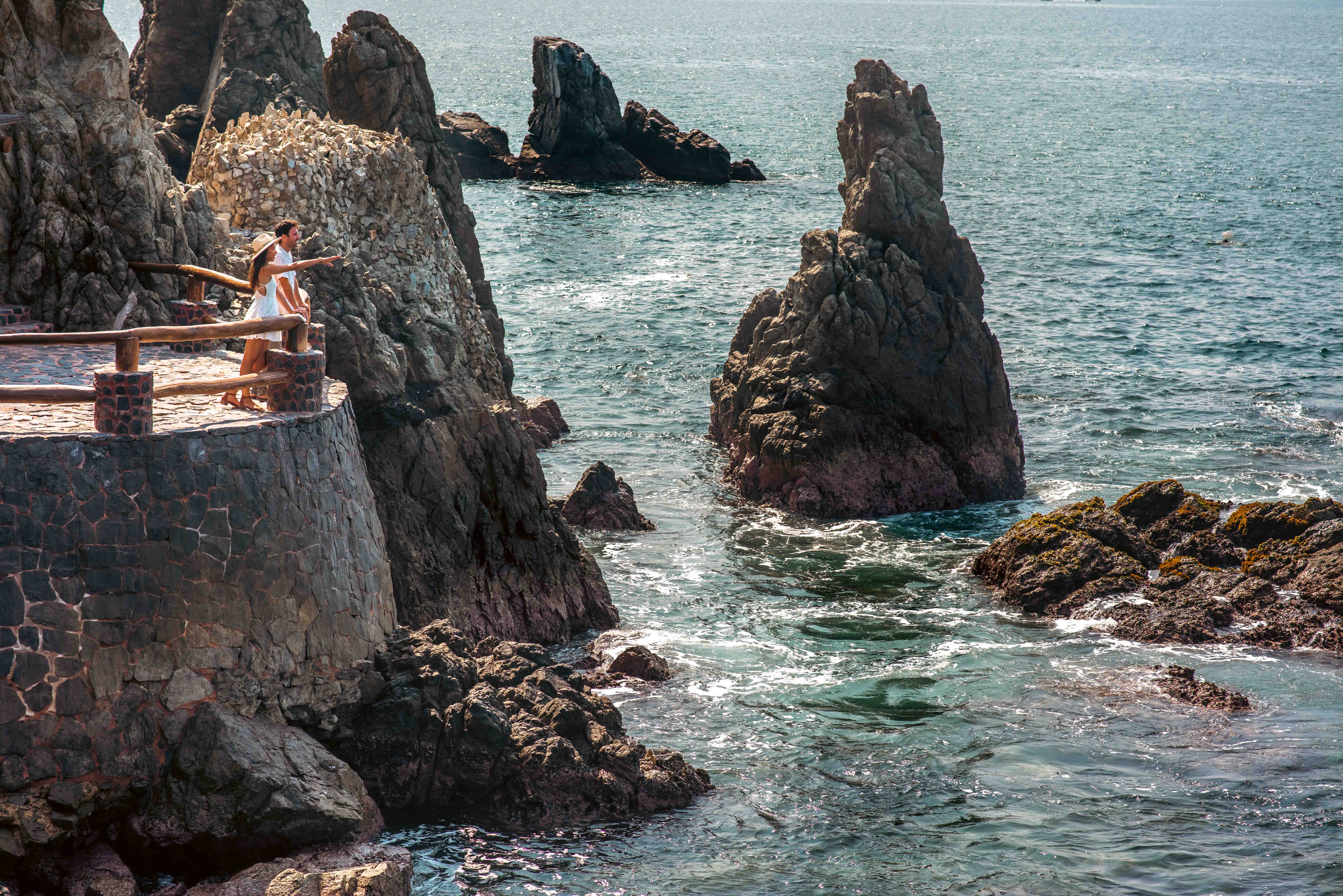 Couple looking out over the Pacific Ocean from the cliffs at La Casa Que Canta in Zihuatanejo