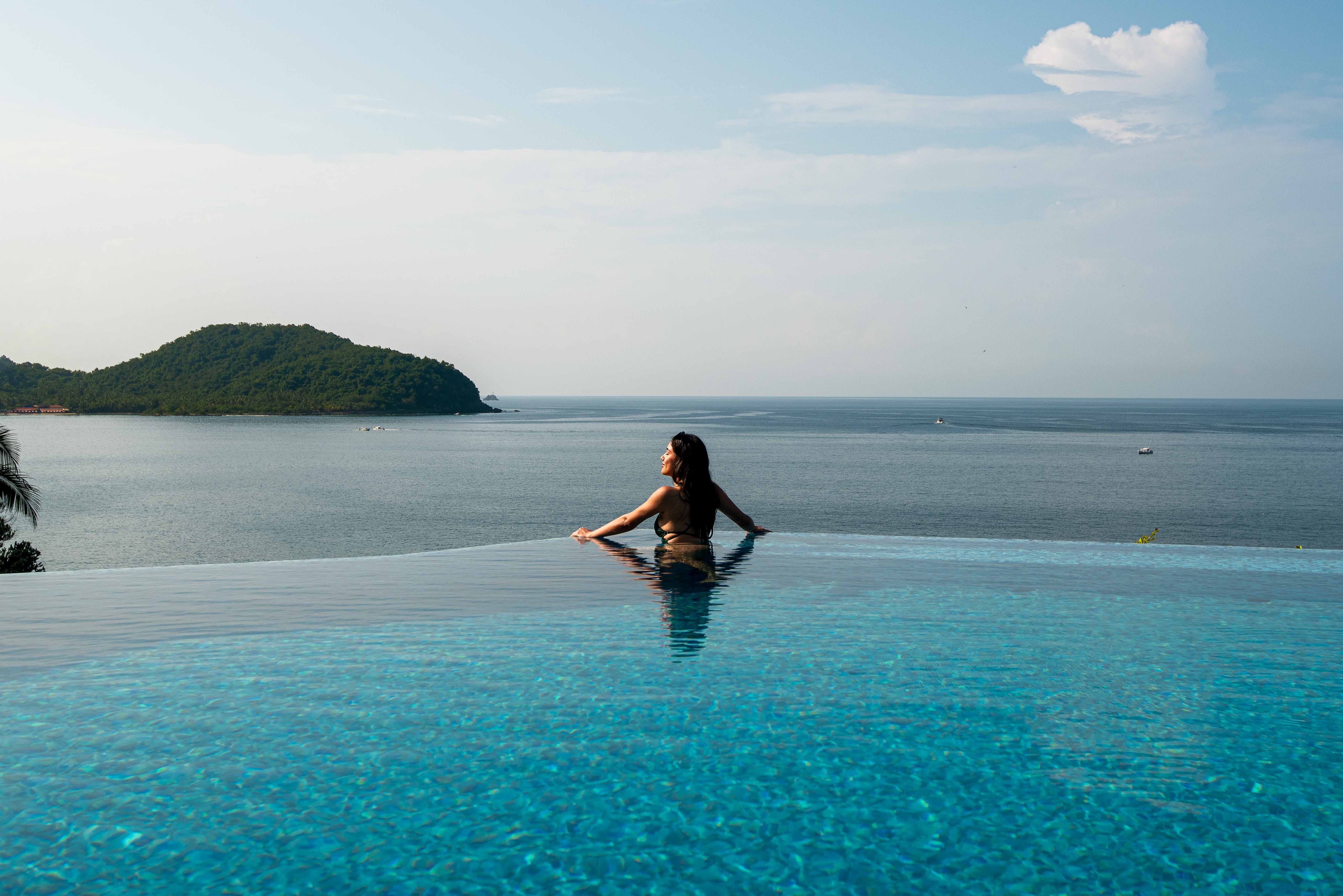 Woman in the infinity pool overlooking the Pacific Ocean at La Casa Que Canta in Zihuatanejo