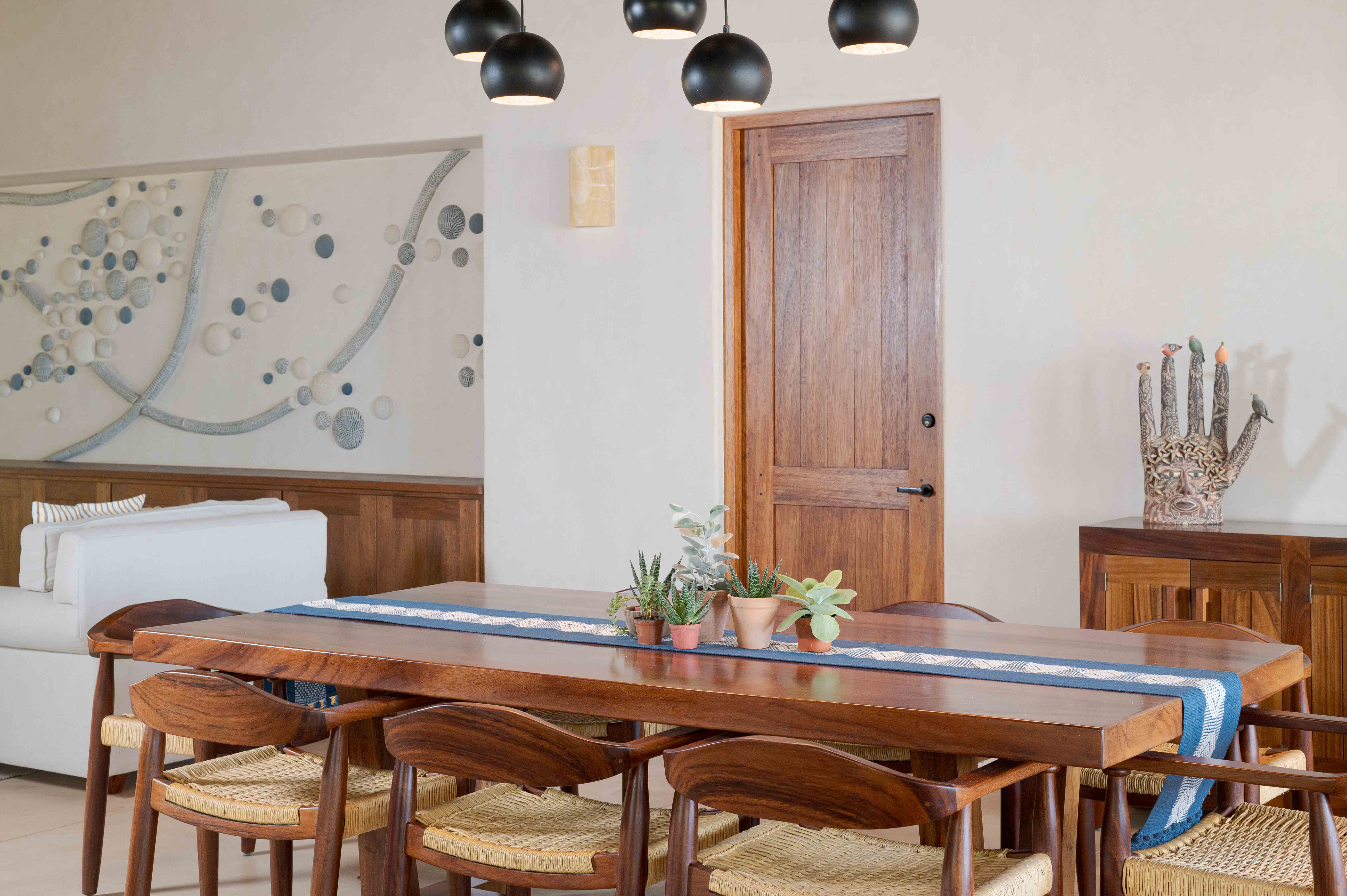 Living and dining room with sculptures, tile, wood, ceramics and artistic lighting in Mexico