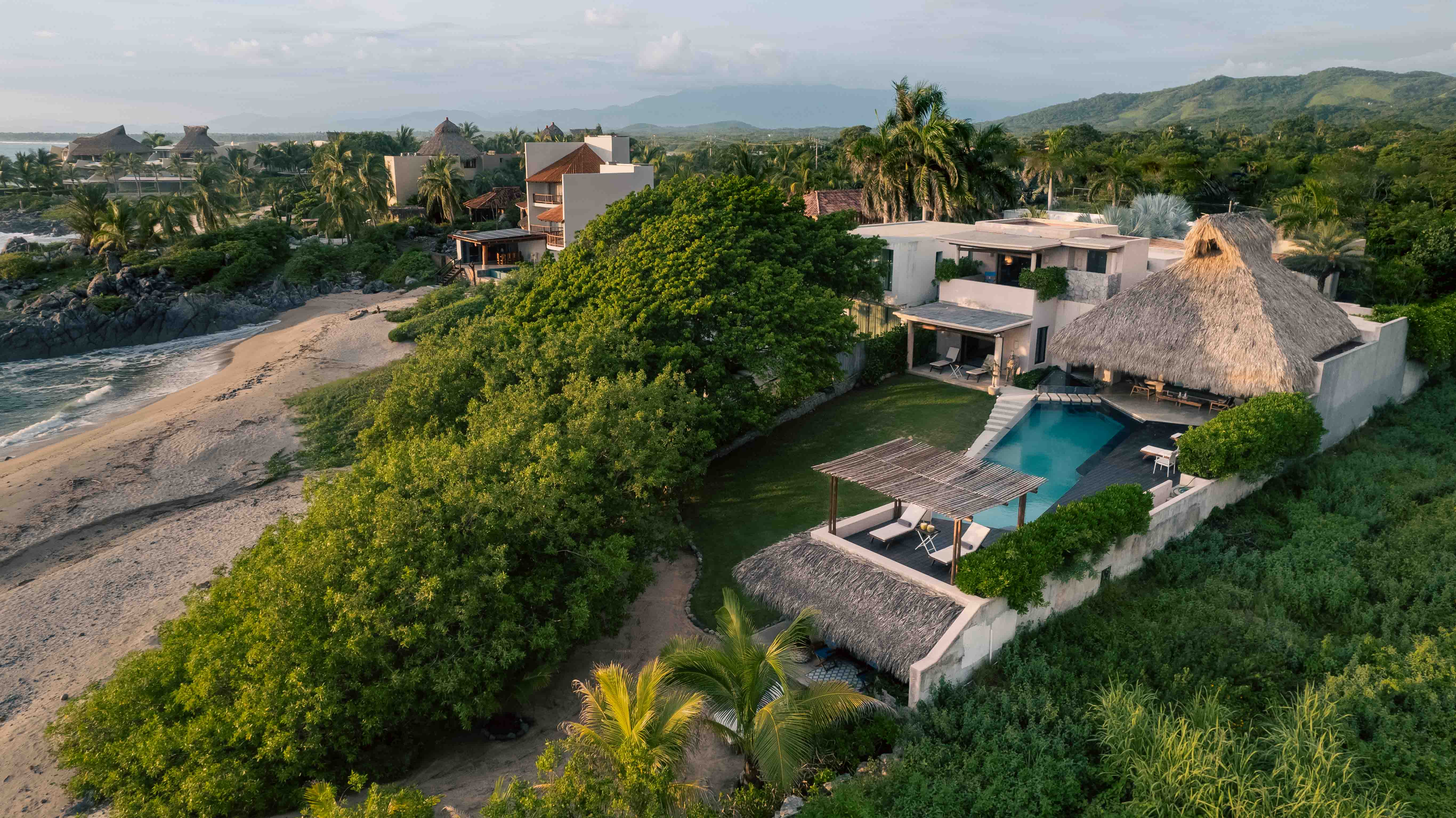 Aerial view of a beachfront house with ocean and mountain views designed by Zozaya Arquitectos