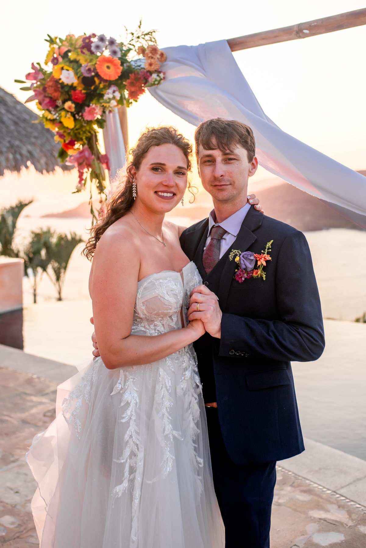 Bride and groom dip their toes in the surf, reveling in the joy of their beachside celebration