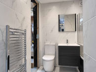 Modern tiled bathroom with toilet and wall-mounted vanity