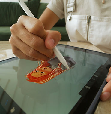 Student hands using a stylus to create digital artwork, expressing creativity through technology and visual storytelling