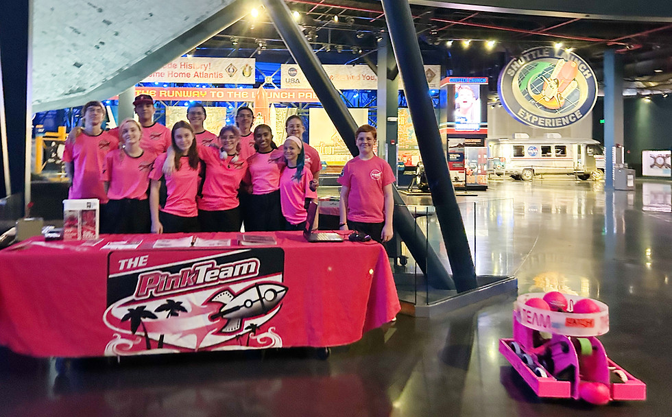 The Pink Team posing at a NASA event with O-BOT
