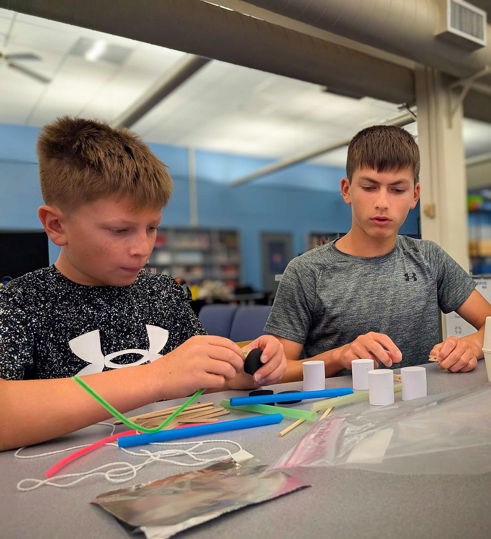 Two boys building with craft supplies at summer camp
