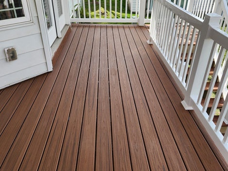 Close-up of premium composite decking boards with white aluminum railing and custom deck construction.
