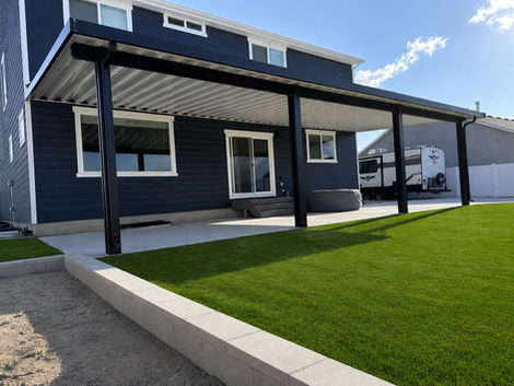 Extra-wide insulated aluminum patio cover spanning the length of a two-story home and backyard patio.