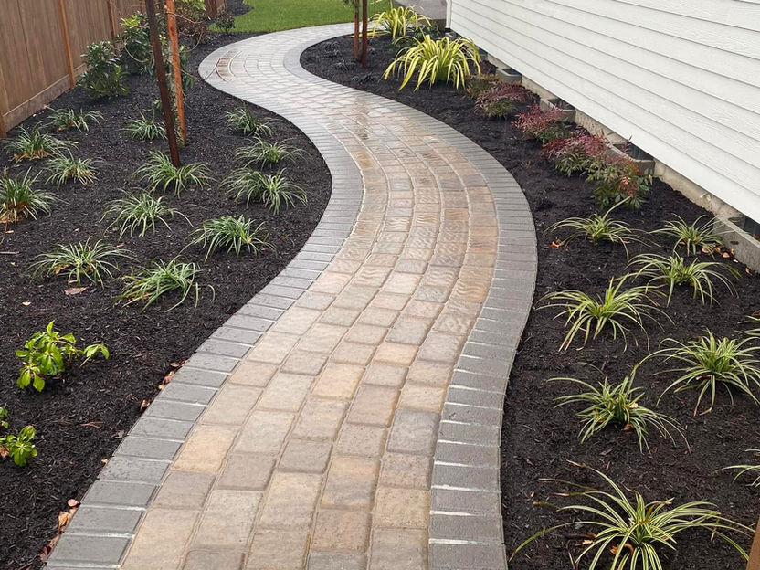 Paver walkway installation with curved garden bed edging in West Jordan Utah