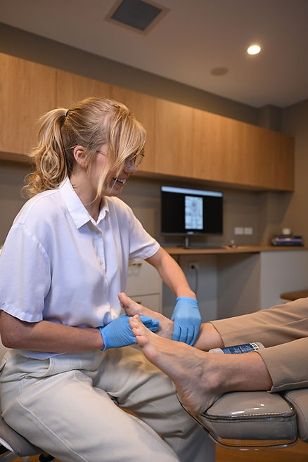 Dr Merridy Lithgow examining a patient's foot and ankle in clinic