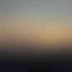 The sun dropping behind a beautiful swath of clouds as it sets
