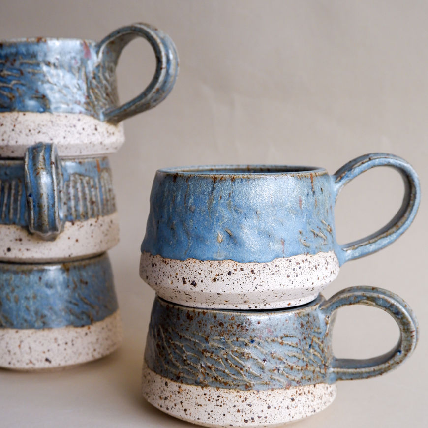 Stack of blue and white speckled Kovalska ceramic mugs
