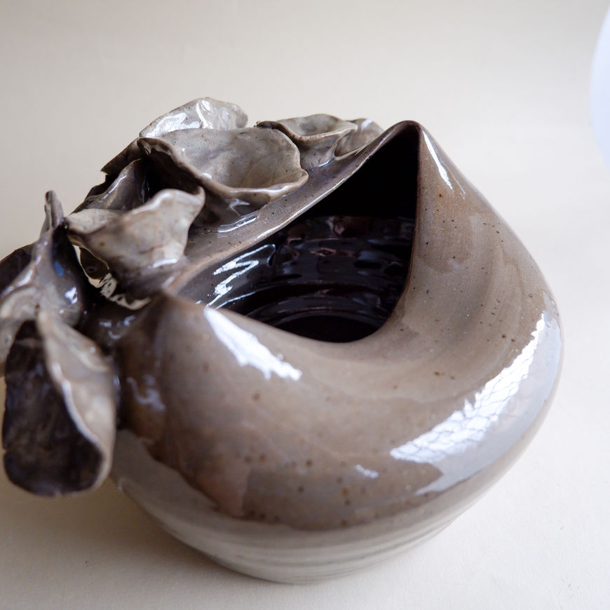 A striking piece from "The Floral" collection, carefully hand-built from dark brown stoneware with a special curved shape.