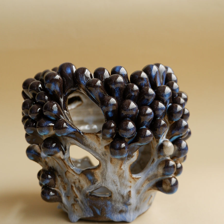 An elegant fusion of form and texture: a vase with elaborate cutouts.