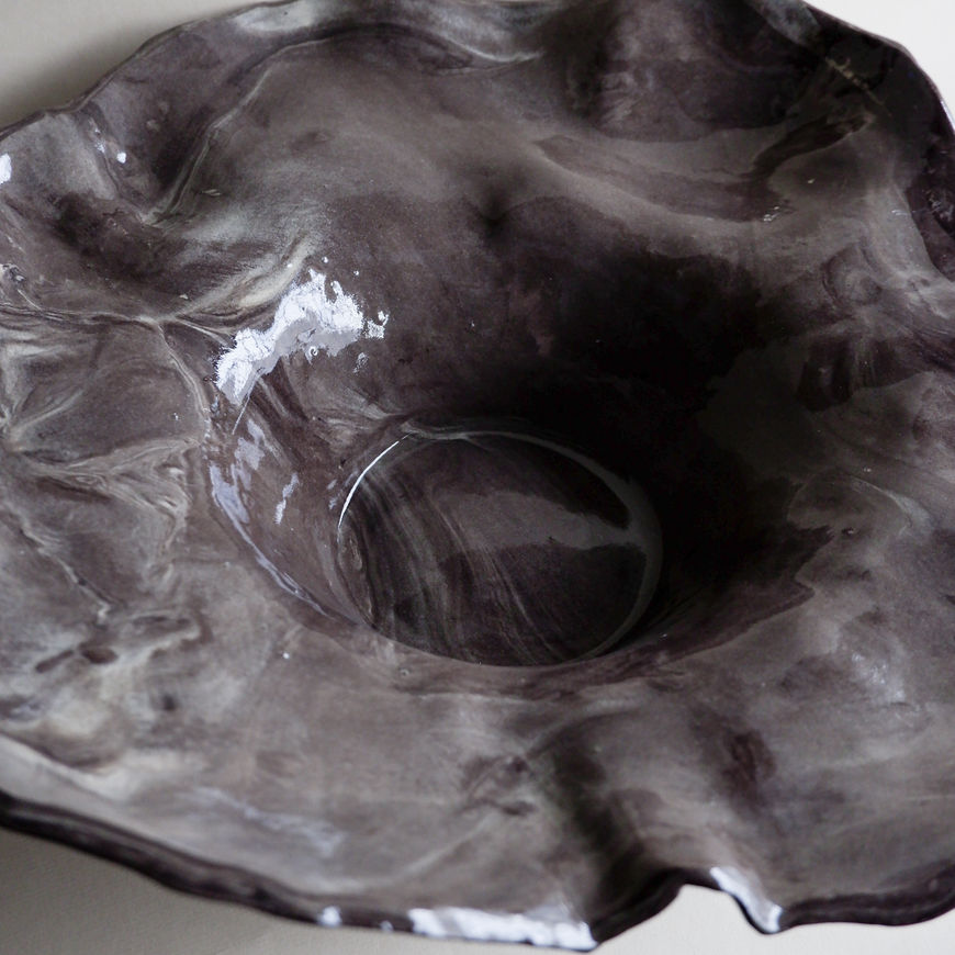 The floral marbled centerpiece, made of dark stoneware, is a bold and sophisticated piece that enhances any space.