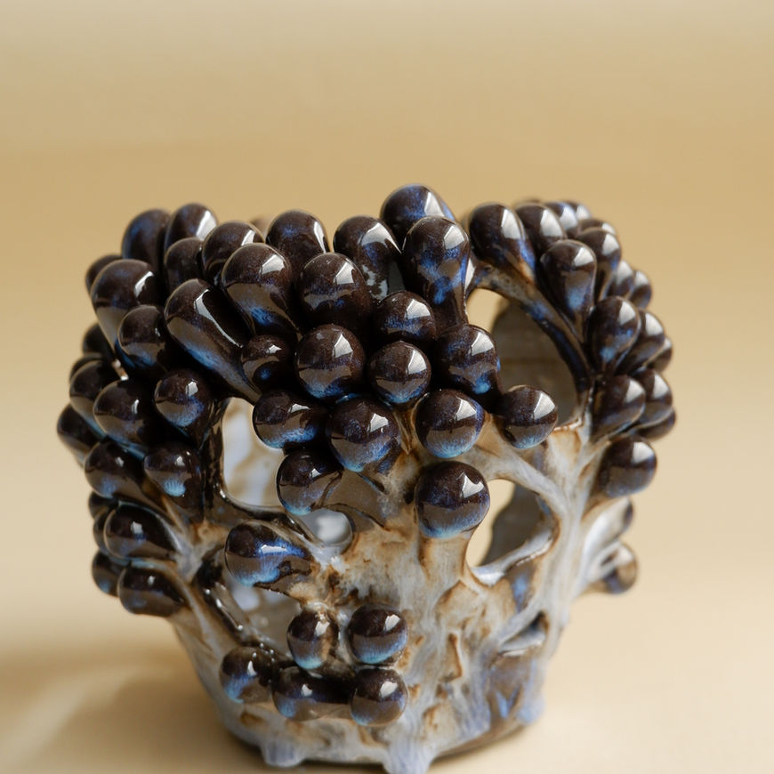 A stunning vase adorned with elaborate patterns and multiple openings.