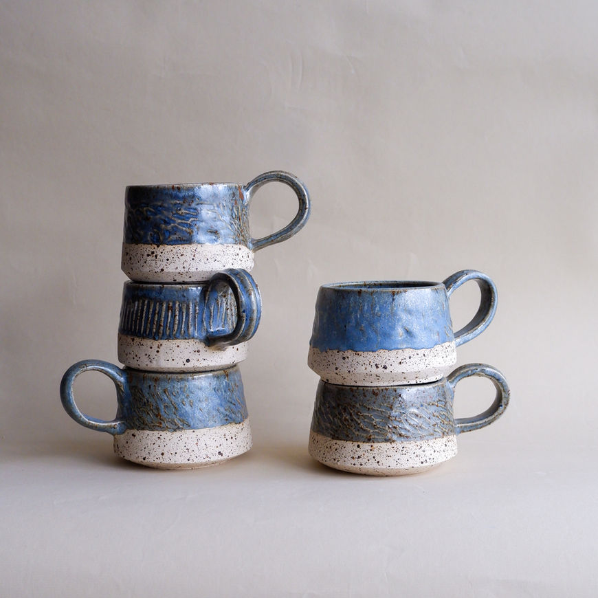 Stack of blue and white speckled Kovalska ceramic mugs