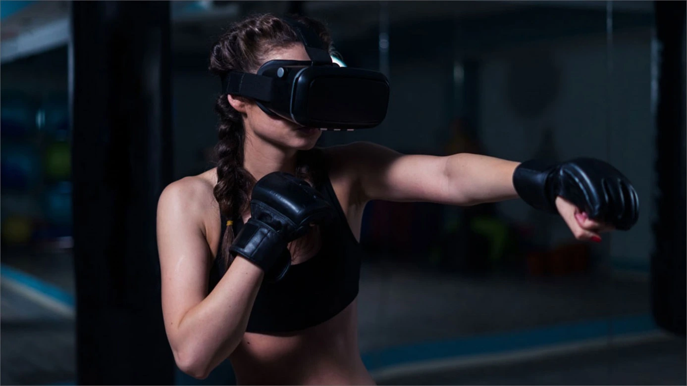 Une femme s'adonne à la boxe virtuelle avec passion dans une salle de sport. Malgré l'absence d'un adversaire réel, elle se donne à fond, utilisant les mouvements précis et les techniques apprises pour améliorer sa force, sa vitesse et sa coordination.