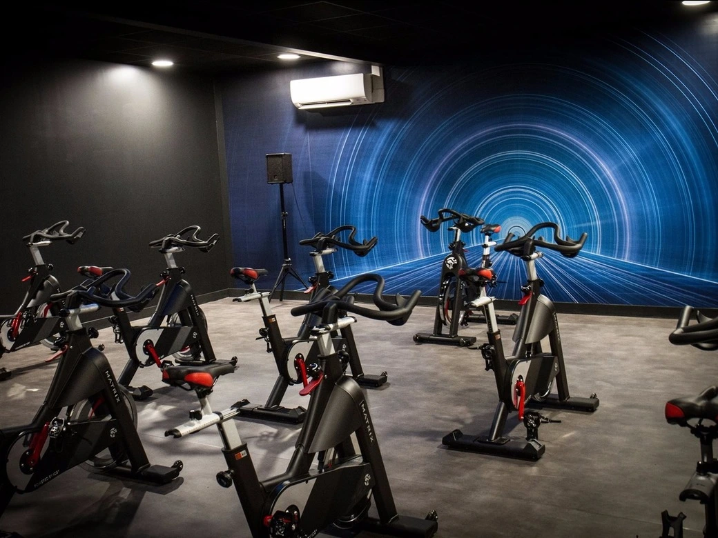 Dans cette salle de sport moderne et dynamique de GigaFit Verrières Le Buisson, vous découvrirez un espace dédié au cyclisme indoor. Des rangées de vélos stationnaires sont prêts à accueillir les passionnés de cardio et de pédalage. Les lumières tamisées et l'atmosphère énergique créent une ambiance propice à l'effort et à la motivation.