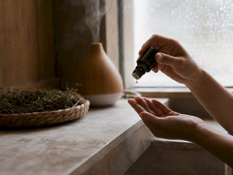 Hands pouring facial oil drops on fingertip