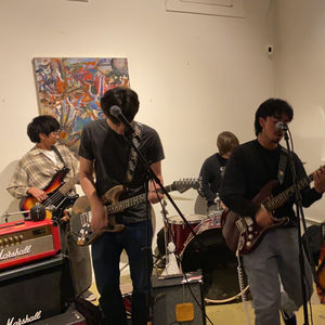 Band playing live music, various artworks on wall, El Callejon Gallery.