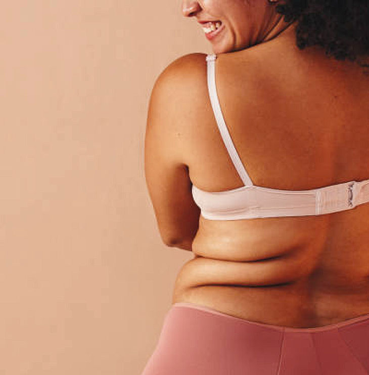 Close-up view of a woman’s back and shoulder with soft natural light