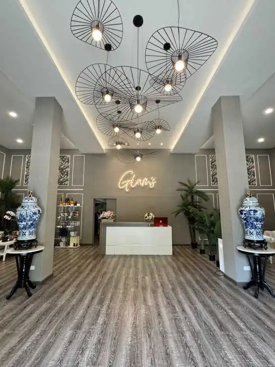 A lobby of glam's Massage featuring a stunning large chandelier hanging from the ceiling, creating an elegant atmosphere